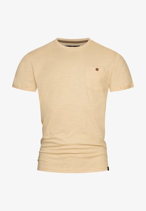 T-shirt beige clair à manches courtes avec une texture douce, col rond et une poche poitrine avec un détail de bouton marron.