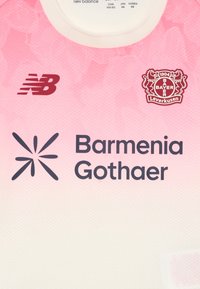 Bayer Leverkusen fotbollströja i en gradiente av rosa och vitt. Har New Balance-logotyp, Barmenia Gothaer-text och klubbens emblem. Texturerad tyg.