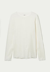Camisa de manga larga con cuello redondo en color blanco roto, confeccionada en algodón suave, con un dobladillo ondulado y una textura sutil.