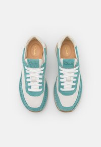 Sneaker in pelle turchese e bianca con finitura testurizzata, dotate di lacci bianchi, soletta imbottita e suola in gomma marrone.