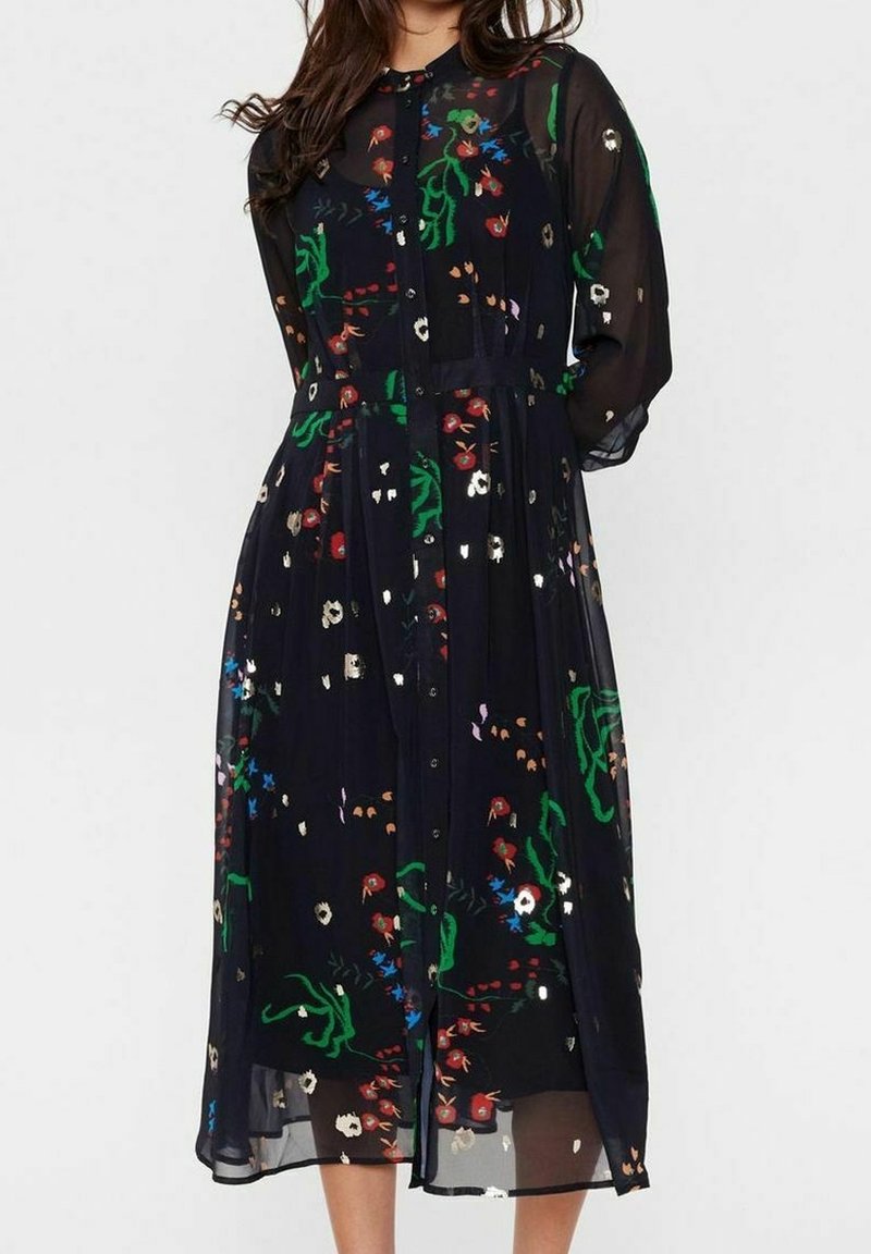 Robe noire à fleurs en tissu léger et transparent. Présente des motifs floraux multicolores, des manches longues et une fermeture éclair à boutons sur le devant.