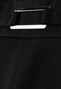 Ceinture en tissu noir avec une boucle rectangulaire en métal argenté. Présente une texture lisse et des coutures précises le long des bords.