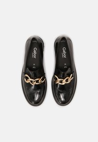 Svarta läderskor med en glansig finish, prydda med en gyllen kedjedetalj över foten. Inuti märkeslogotyp: "Gabor comfort, H, 4½."