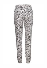 Elastīga josta biksēm ar šauru piegriezumu, ar krēmkrāsas fona un tumši ziliem punktiem. Audums izskatās mīksts ar gludu tekstūru.