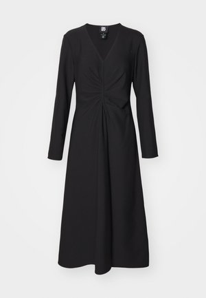 Must võõrastega must pikkade varrukatega kleit V-kaelusega, millel on rüüf-detail taljes ja voolav A-line siluett. Sile kangateksuur.