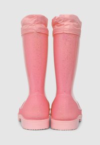 Stivali da pioggia in gomma rosa con finitura lucida, caratterizzati da una texture scintillante, polsini in tessuto rosa corti e una suola piatta e scanalata.