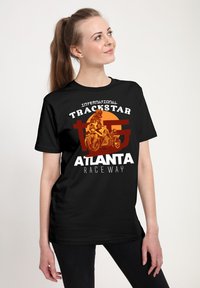 Svart bomullst-shirt med en grafisk design som har "Trackstar Atlanta Raceway", orange detaljer och en motorcykelillustration.