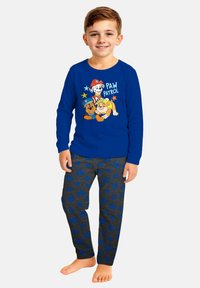 Camicia a maniche lunghe blu con graphic di "Paw Patrol" e pantaloni del pigiama grigi con motivi a impronta di zampa blu. Materiale in misto cotone.