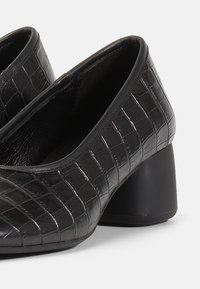 Pantofi cu toc înalt negri, cu textură din piele de crocodil, vârf rotund și toc pătrat. Finisaj neted cu un design clasic.