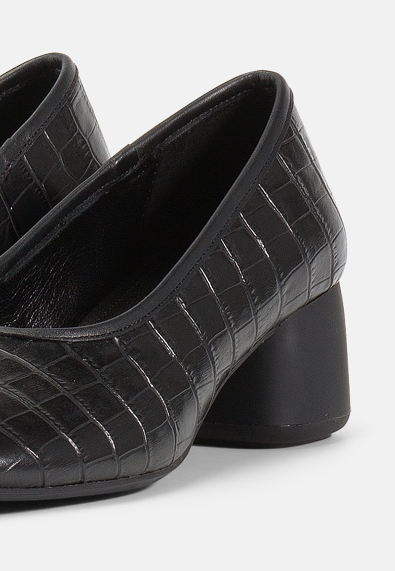 Schwarze High Heels mit Krokodilprägung, runder Spitze und Blockabsatz. Glatte Oberfläche mit klassischem Design.