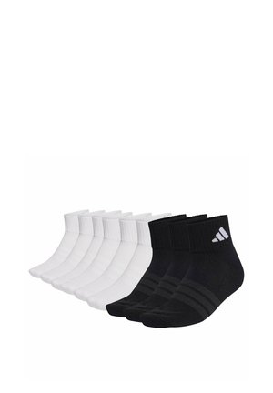 Eight pairs of ankle socks, five white and three black with gray stripes and a white logo on the cuff of the black socks.