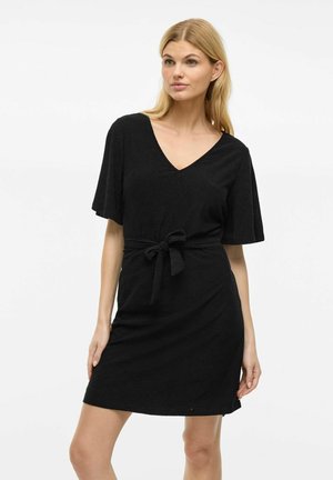 Robe noire courte avec un col en V, des manches courtes et un détail de taille nouée. Le tissu présente un motif texturé. Design simple et ajusté.