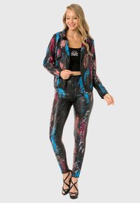 Black leather jacket and pants with colorful paint splatters in blue, pink, and white. Jacket has a zipper front; pants feature printed text.