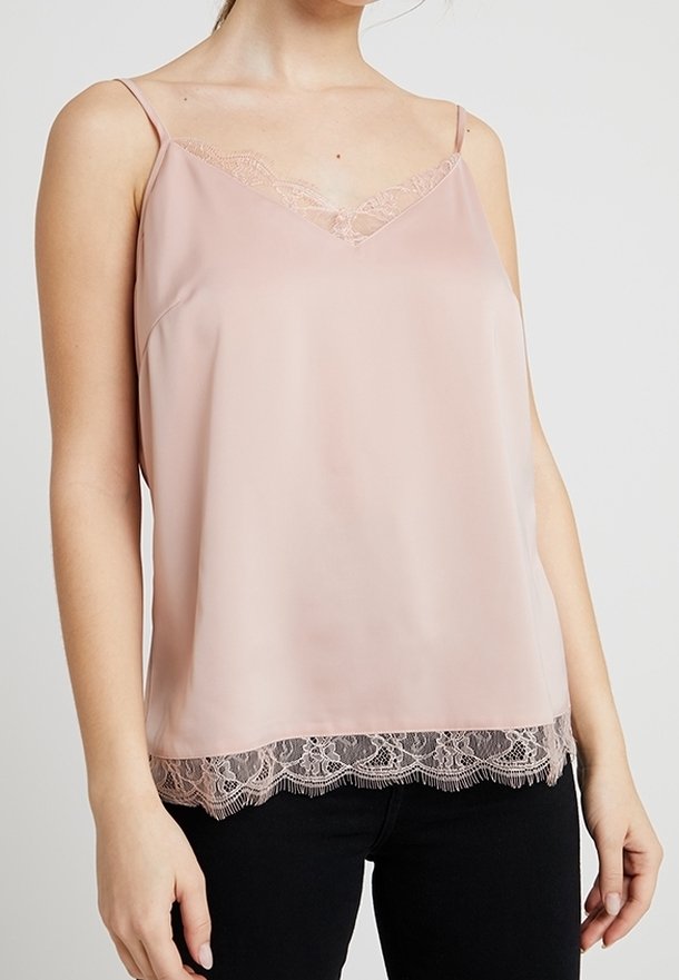 Camisole en satin rose clair avec des finitions en dentelle délicate le long de l'encolure et de l'ourlet, présentant des bretelles fines et une coupe décontractée.