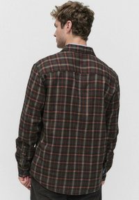 Langärmliges karriertes Hemd in Braun-, Grün- und Rottönen. Mit einem Button-Down-Kragen und einem abgerundeten Saum, aus gewebtem Baumwollstoff gefertigt.
