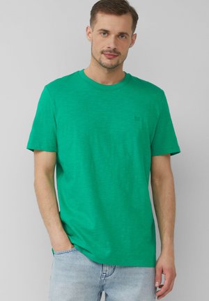 Groene katoenen T-shirt met een ronde hals, korte mouwen en een subtiele logodetail op de borst. Zachte textuur en een ontspannen pasvorm.