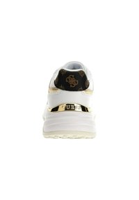 Sneaker bianco con tacco nero testurizzato che presenta un logo, dettagli dorati e un collare imbottito. Suola liscia e arrotondata con motivi di battistrada ben definiti.