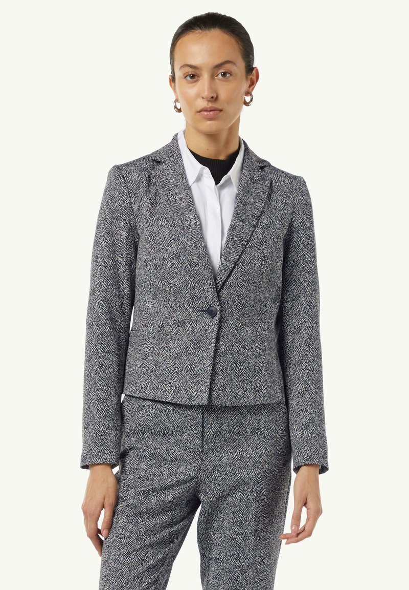 Tailored blazer in a herringbone pattern, gray with black accents. Features a single button closure and structured fit. Smooth fabric texture.