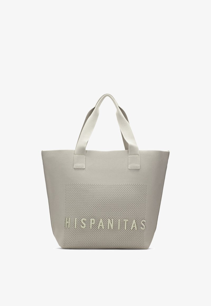 Sac cabas beige avec panneau avant texturé présentant des lettres en relief "HISPANITAS" et deux poignées solides.