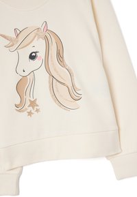 Felpa color crema con un design di unicorno, dotata di un corno luccicante e stelle, texture morbida e polsini a costine.