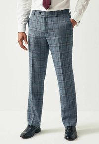 Karierte Hose in Blau und Grau aus strukturiertem Stoff. Mit schmaler Passform, Seitentaschen und schwarzen Anzugschuhen.