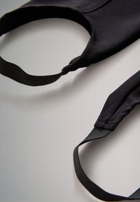 Mustast kangast näomask, millel on pehmed elastsed rihmad ja struktureeritud disain tihedaks sobivuseks. Sile tekstuur ilma nähtavate mustriteta.