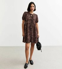 Robe à imprimé léopard avec manches bouffantes, corsage ajusté et jupe légère. Associée à des mocassins noirs et un petit sac noir.