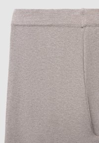 Helle graue Leggings aus einem weichen, strukturierten Stoff. Sie verfügen über einen elastischen Bund und eine glatte Oberfläche ohne Muster oder Akzente.