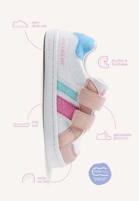 Zapatilla blanca para niños con rayas en rosa, azul y turquesa, cierres ajustables, suela fina y de caída cero, puntera ancha y diseño flexible.