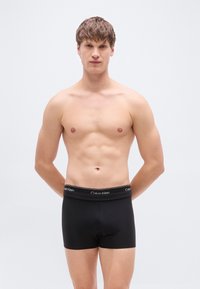 Μαύρα βαμβακερά μποξεράκια με φαρδιά ελαστική ζώνη μέσης που φέρει το λογότυπο Calvin Klein. Λείο ύφασμα και εφαρμοστή σχεδίαση.