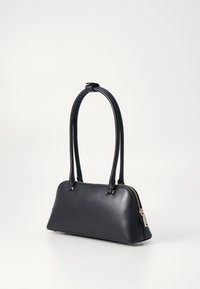 Bolsa de mão em pele preta com forma estruturada, alças curvas duplas, fecho de zip e pequenos detalhes decorativos em metal. Textura suave.