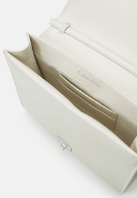 Calvin Klein ARCHIVE SHOULDER BAG SHINY - Bolso de mano - ecru