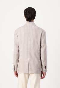 Light gray striped blazer in lightweight fabric, features a single vent, two back seams, and brown button accents on the cuffs.