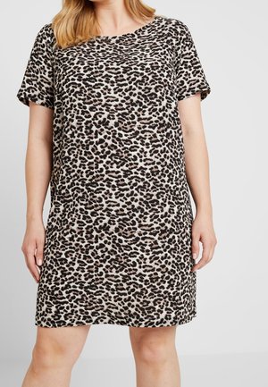 Donna che indossa un vestito a maniche corte, lungo fino al ginocchio, con motivo leopardato nero e beige su sfondo chiaro.