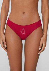 Czerwone majtki od bikini wykonane z gładkiej tkaniny, z białym wzorem choinki z kryształków na froncie i niskim stanem.