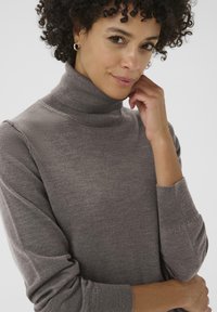 Grauer Rollkragenpullover aus weichem Strickstoff, mit langen Ärmeln und gerippten Bündchen sowie einer figurnahen Silhouette.