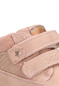 Zapato de ante rosa con patrones de estrellas, correas de velcro y un acento metálico en el talón. Textura suave y cuello acolchado para mayor comodidad.