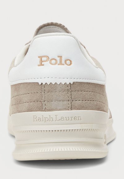 Beige suede sneaker with white leather accents. Features embossed "Polo" logo and "Ralph Lauren" text on the heel, textured sole.
