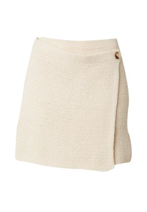 Gebreide wikkeltanqun in lichtbeige, met een textuur oppervlak, asymmetrische zoom en een knoopaccent aan de zijkant voor sluiting.