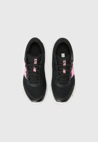 Des baskets noires avec des accents roses présentent une tige en mesh respirant, un design à lacets et une semelle en caoutchouc blanche. Le numéro de modèle 578 est visible.
