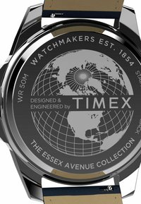 Cassa dell'orologio in acciaio inox con quadrante nero caratterizzato da un design della mappa del mondo e dettagli argentei; cinturino in pelle nei colori tan e navy. Impermeabile fino a 50 metri.