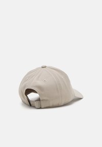 Cappellino da baseball beige in cotone con visiera curva, cinturino regolabile sul retro e sei fori di ventilazione.