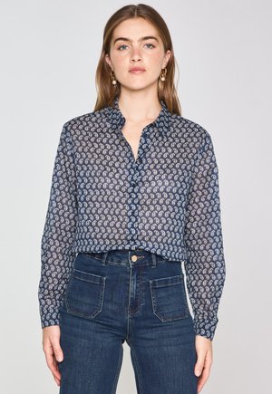 Navy blue sheer blouse with button closure, featuring a repeating light-colored paisley pattern, long sleeves, and a classic collar.