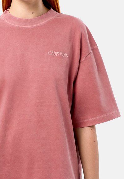 Pink oversized t-shirt featuring a round neckline and short sleeves. Includes "CAMPERLAB" embroidered logo in a contrasting color on the chest.