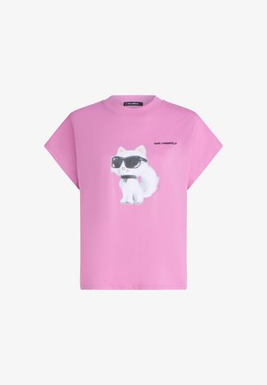 Roosa T-särk valge kassi kujutisega, kes kannab musti prille ja kaelarihma, ning varem kirja "Karl Lagerfeld" trükiti kassi kõrvale esiplaanil.