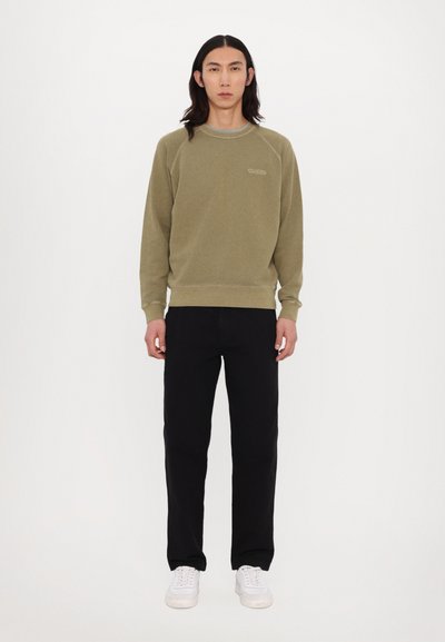 Khaki sweatshirt med rund halsudskæring og ribbede manchetter, parret med sorte lige bukser og hvide sneakers. Enkel design, uden mønstre.