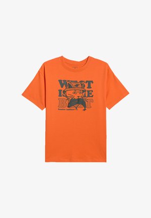 T-shirt orange à manches courtes avec un graphisme d'un chat portant un chapeau tenant un poisson, texte "WIT IS THE BEST" et "hunter instinct."