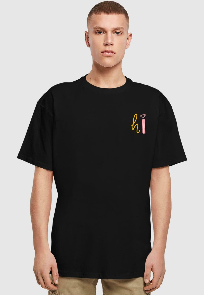 Černé bavlněné tričko s krátkým rukávem, které na hrudi zdobí barevná grafika "ahoj". Volný střih, kulatý výstřih, jednoduchý design.
