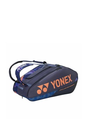 Bolsa deportiva Yonex de alto rendimiento en azul marino y morado, con dos compartimentos con cremallera y correas dobles para llevar.