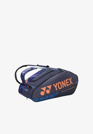 Marineblauwe en paarse Yonex professionele sporttas met twee met ritsen afsluitbare vakken en dubbele draagriemen.